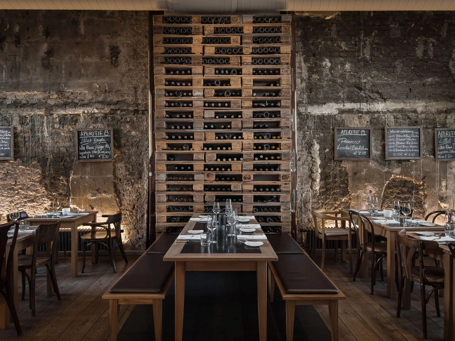 Interior view of the restaurant dining area with industrial brick walls and wooden tables.